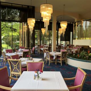 Elegant restaurant interior with chandeliers and large windows.
