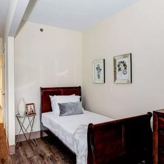 A cozy bedroom with a single bed, wooden furniture, and elegant wall decor.