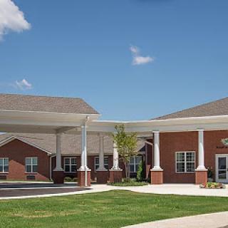 A welcoming entrance to a modern building under a clear blue sky.