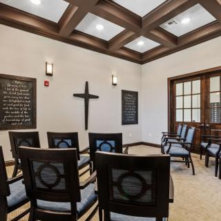 A small chapel with arranged chairs and decorative ceiling lights.