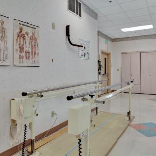 A physical therapy room equipped with parallel bars for rehabilitation exercises.