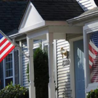 A house with an American flag displayed on the porch.