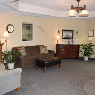 A cozy living room with comfortable seating and decorative plants.