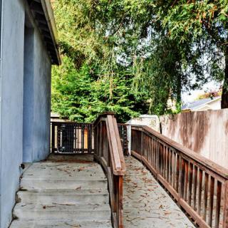 An outdoor pathway with a wooden ramp and stairs alongside a building.