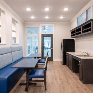 A modern kitchen and dining area with built-in seating and overhead lighting.