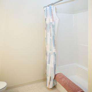 A clean and simple bathroom featuring a shower curtain, towel, and toilet.