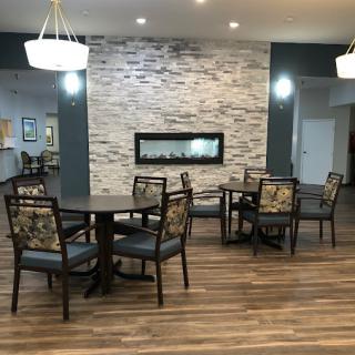A modern lounge area featuring comfortable seating, a stylish fireplace, and warm lighting.