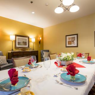 A beautifully set dining table in a well-lit room, complete with elegant decor and artwork on the walls.