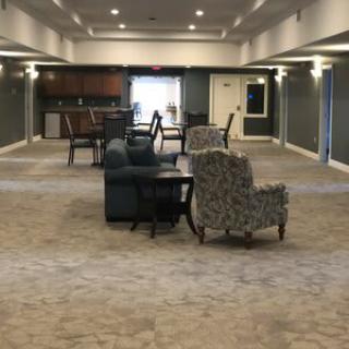 A spacious lounge area with comfortable seating arrangements and warm lighting.