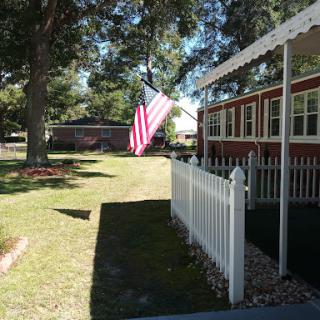 A sunny day in a residential area with an American flag proudly displayed.