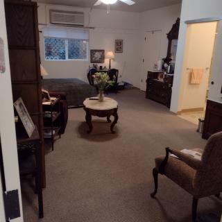A cozy living room with various pieces of furniture and a window.