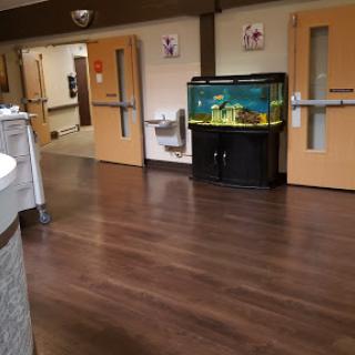 A view of a hospital interior featuring an aquarium and wooden flooring.