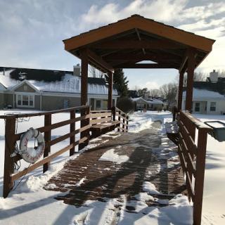 A serene winter scene featuring a wooden bridge covered in snow, inviting exploration.