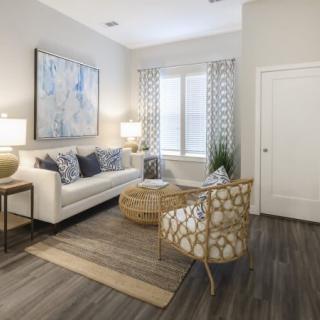 A modern living room featuring a white sofa, patterned chairs, and elegant decor.
