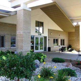 Entrance of a modern building with landscaping and gardens.