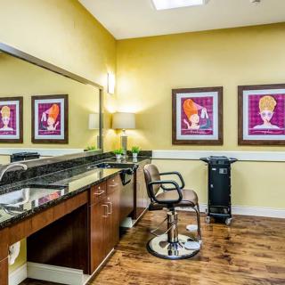 A stylish hair salon with a barber chair, mirror, and vibrant artwork on the walls.