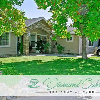 Front view of a residential care home with a landscaped lawn and parked car.