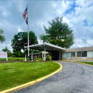 A welcoming entrance with a flagpole and landscaped surroundings.