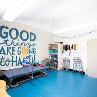 A bright and inspiring room with motivational wall art and organized shelves, featuring a blue floor.