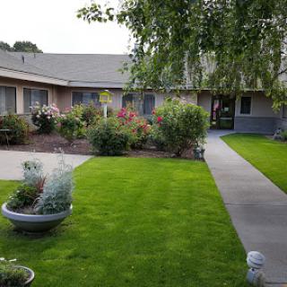 A serene residential courtyard featuring well-maintained lawns and vibrant flowers.