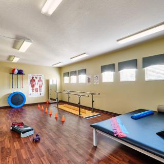 A well-equipped physical therapy room with various exercise tools and apparatus for rehabilitation.