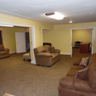 A spacious living room with multiple sofas and yellow walls.