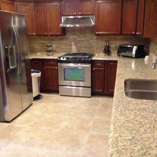 Modern kitchen with stainless steel appliances and wooden cabinets.