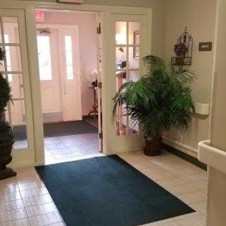 A welcoming entrance with soft carpeting and greenery.