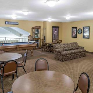 A cozy lounge area with tables and chairs, featuring a sofa and various decorations on the walls.