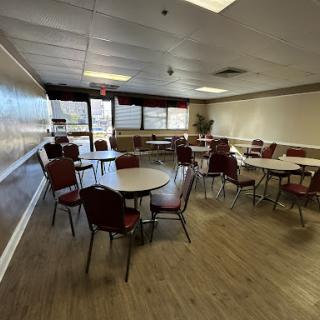 A spacious dining area with round tables and chairs, designed for gatherings or events.