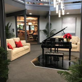 A modern lobby with a grand piano and comfortable seating area.