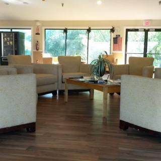A well-lit waiting room with comfortable chairs and tables arranged for guests.