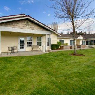 A spacious house with a well-maintained lawn and clear blue sky.