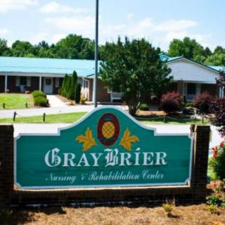 Entrance sign for GrayBrier Nursing & Rehabilitation Center with building in the background.