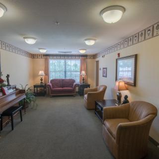 A cozy living room with comfortable seating and a piano.