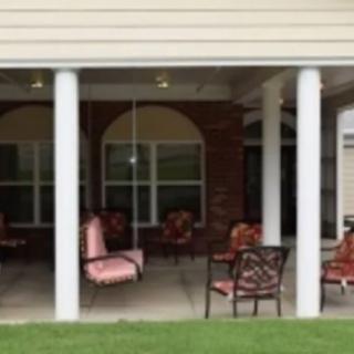 A covered patio with outdoor seating and columns.
