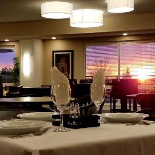 A beautifully set restaurant table with a stunning sunset view in the background.