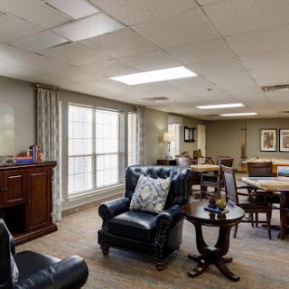 A cozy living space featuring comfortable seating, natural light streaming through large windows, and a warm ambiance.