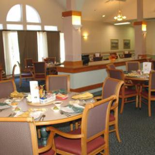 A well-lit dining area with neatly arranged tables and chairs.