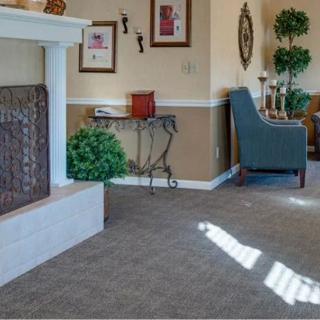 A cozy living room with a fireplace, comfortable chair, and elegant decor.