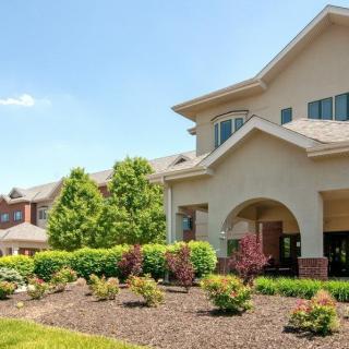 A suburban house with well-maintained landscaping under a clear blue sky.