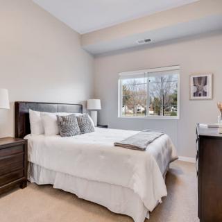 A well-lit bedroom with modern decor and a comfortable bed.