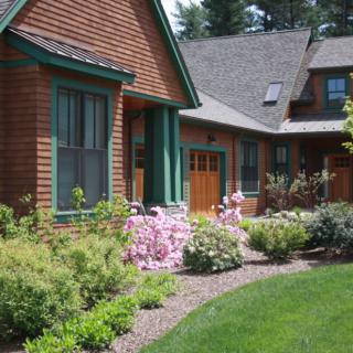 A charming house with a beautifully landscaped garden featuring vibrant flowers and lush greenery.