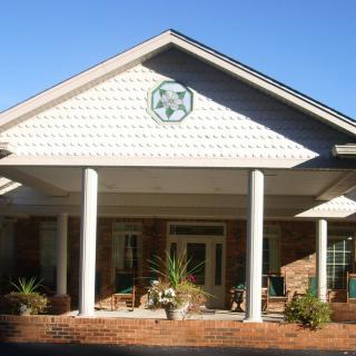 Front view of a building with columns and a porch.