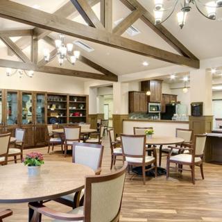A modern dining area with wooden beams and elegant chandeliers.