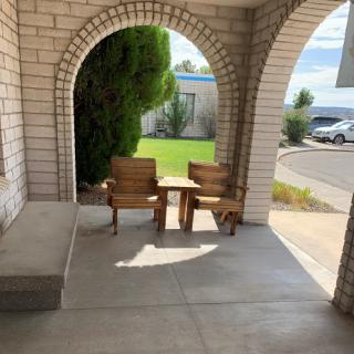 A cozy porch area with wooden furniture, inviting relaxation in the sunlight.