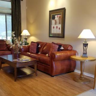A cozy and modern living room featuring a leather sofa, decorative lamps, and a wooden coffee table.