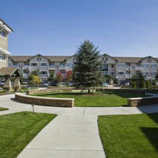A view of a residential apartment complex with well-maintained lawns and pathways.