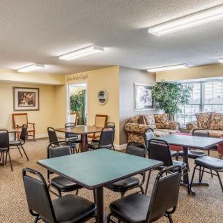 A cozy lounge area with multiple seating arrangements, tables, and decor.