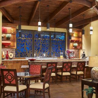 A warmly lit bar and restaurant interior with stylish seating and decorative accents.